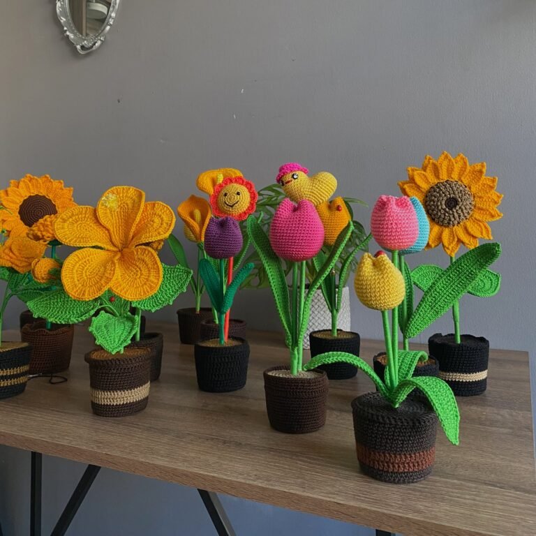 Fila de macetas con girasoles y tulipanes de croché sobre la mesa del taller
