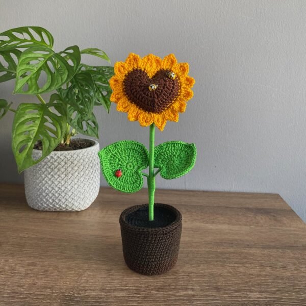 Girasol de croché con el centro en forma de corazón, en maceta blanca