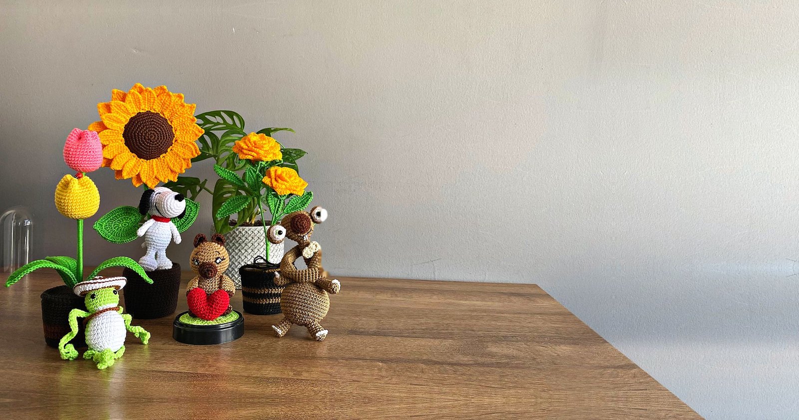Flores y amigurumis de croché sobre una mesa de madera