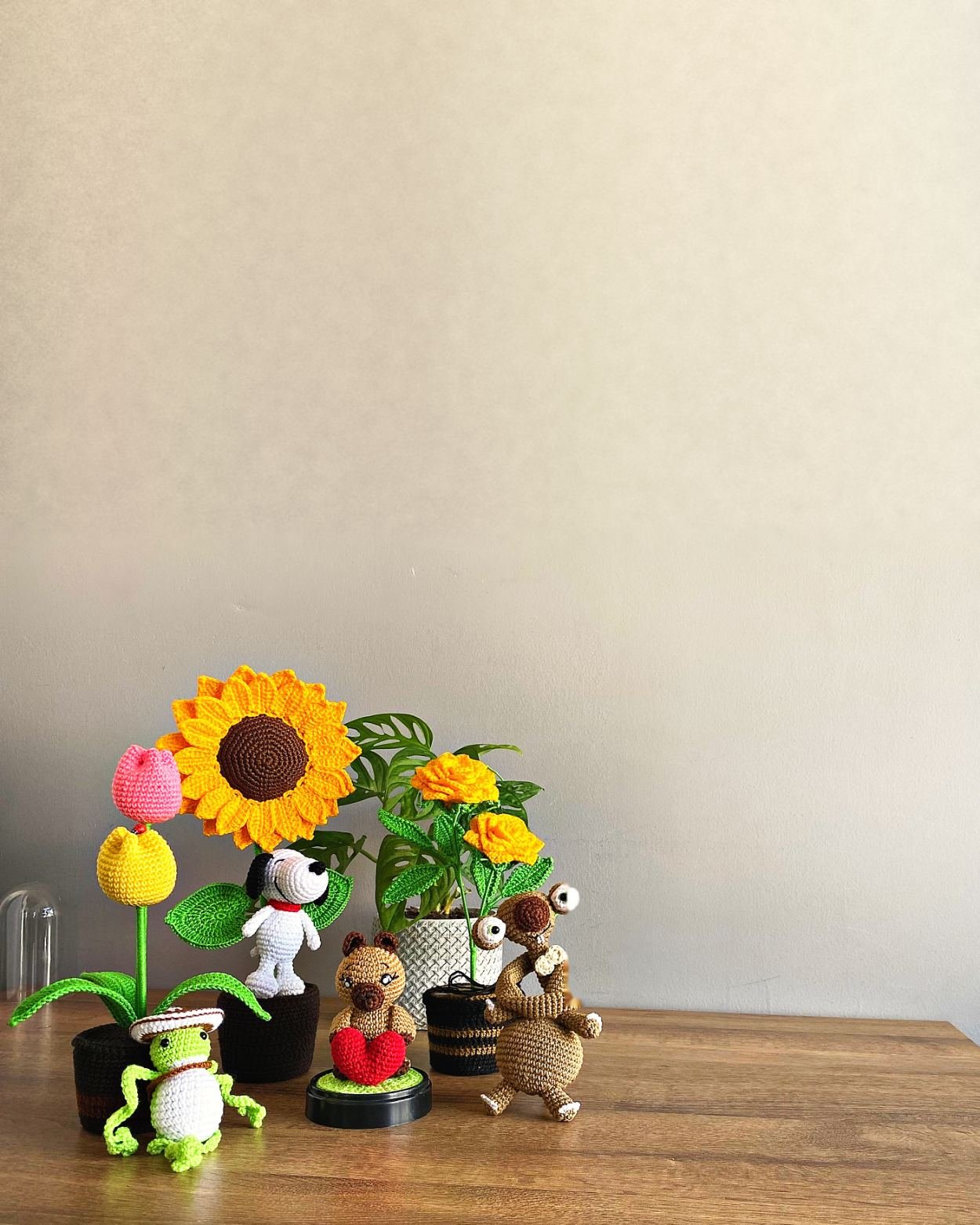 Girasoles de croché en maceta junto a un amigurumi